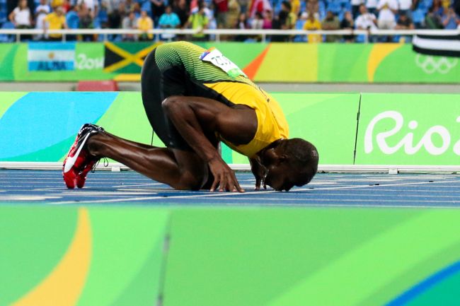 男子200メートルで3連覇を達成し、フィニッシュラインにキスする